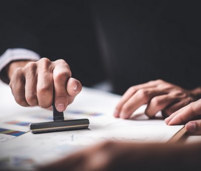 Close-up Of A Person's Hand Stamping With Approved Stamp On Text Approved Document At Desk,  Contract Form Paper